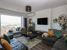 A living room with a sofa and a TV at Sea View in Llandudno