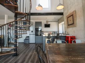 A kitchen with a spiral staircase and a dining table at Sea View in Llandudno