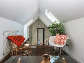A loft with a rocking chair and a glass table at Sea View in Llandudno