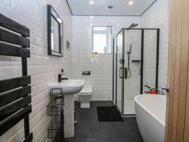 A bathroom with a sink, shower, bathtub and towel radiator at Sea View in Llandudno