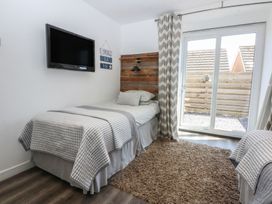 A bedroom with two beds and a television at Sea View in Llandudno