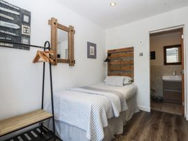 A bedroom with a single bed and a bathroom door at Sea View in Llandudno
