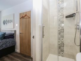 A bathroom with a shower and toilet door at Sea View in Llandudno