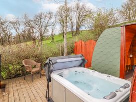 An outdoor area with a hot tub and a chair at The Rhiw in Llanfair Caereinion