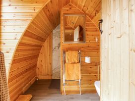 A bathroom with wooden walls and towels on a rack at The Rhiw in Llanfair Caereinion