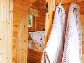 A bedroom with a bed and robes hanging at The Rhiw in Llanfair Caereinion