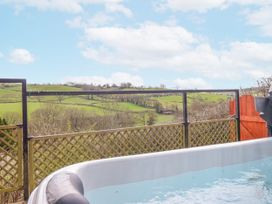 A hot tub with a scenic landscape view at The Rhiw in Llanfair Caereinion
