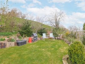 A garden with chairs and a grill at The Rhiw in Llanfair Caereinion