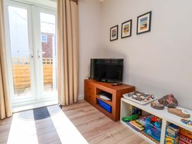 A living room with sliding doors and a television at Driftwood in Filey