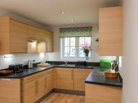 A kitchen with wooden cabinets and a sink at Driftwood in Filey