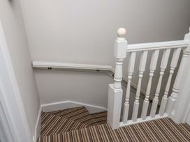 A staircase with carpet and handrail at Driftwood in Filey