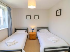 A bedroom with two single beds and a nightstand at Driftwood in Filey
