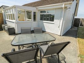 A garden area with a table and chairs at Fern Hill Cottage in Newborough