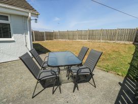 A garden with a table and chairs at Fern Hill Cottage Newborough