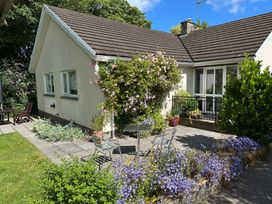 A garden with a house and seating area at Goldcrest in Newport, Pembrokeshire