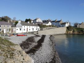 A coastal view with buildings and boats at Hunters Cottage in Benllech