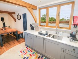 A kitchen with a sink and dining table at The Coach House in Chacombe