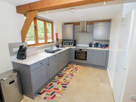 A kitchen with gray cabinets and appliances at The Coach House in Chacombe