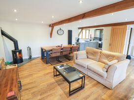 A living room with a sofa and dining area at The Coach House in Chacombe