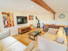 A living room with a TV and a fireplace at The Coach House in Chacombe