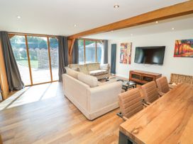 A living room with a sofa and dining table at The Coach House in Chacombe