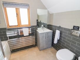 A bathroom with a sink and mirror at The Coach House in Chacombe