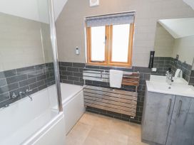 A bathroom with a bathtub and sink at The Coach House in Chacombe