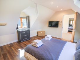 A bedroom with a bed and television at The Coach House in Chacombe