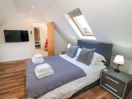 A bedroom with a bed and television at The Coach House in Chacombe
