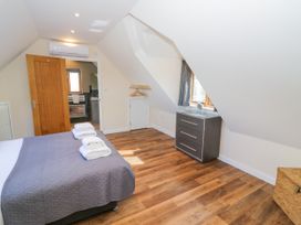 A bedroom with a bed and dresser at The Coach House in Chacombe