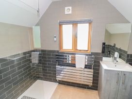 A bathroom with a shower, sink, and mirror at The Coach House in Chacombe