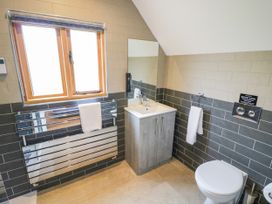 A bathroom with a sink, toilet, towel rail, and window at The Coach House in Chacombe