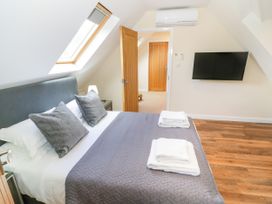 A bedroom with a bed and a TV at The Coach House in Chacombe