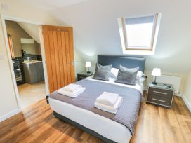 A bedroom with a bed and ensuite bathroom at The Coach House in Chacombe