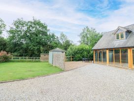 An outdoor area with a house, table, chairs, and shed at The Coach House in Chacombe