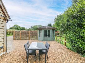 A garden with a table and chairs and a shed at The Coach House in Chacombe