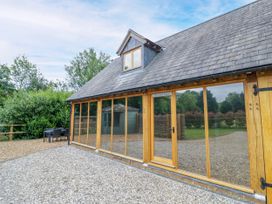 An outdoor view of The Coach House in Chacombe with a gravel area and trees