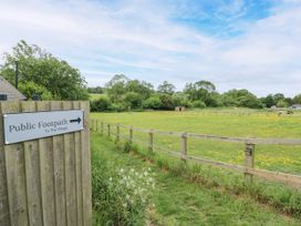 A public footpath sign and fenced area leading to a field at The Coach House in Chacombe