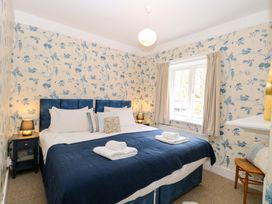 A bedroom with a bed and bedside table at Beckhythe Cottage in Overstrand
