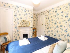 A bedroom with a bed and fireplace at Beckhythe Cottage in Overstrand