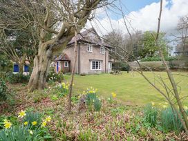 A house with trees and flowers in the garden at Beckhythe Cottage in Overstrand