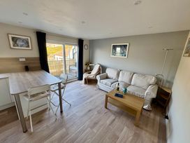 A living room with a sofa and dining space at Gecko Beach in Porthtowan