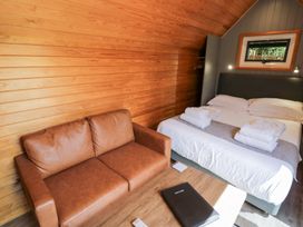 A bedroom with a bed and a sofa at Acorn Lodge At Bridge Lake Farm & Fishery Chacombe