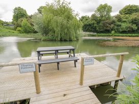 A dock with a table and sign at Acorn Lodge At Bridge Lake Farm & Fishery in Chacombe