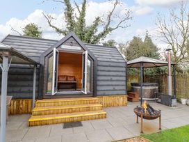An outdoor area with Acorn Lodge and a hot tub at Acorn Lodge At Bridge Lake Farm & Fishery Chacombe