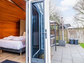 A bedroom with towels on a bed and outdoor area with hot tub at Acorn Lodge At Bridge Lake Farm & Fishery Chacombe
