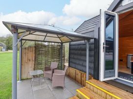 An outdoor seating area with a gazebo and table at Acorn Lodge At Bridge Lake Farm & Fishery, Chacombe