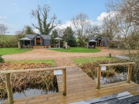 An outdoor area with cabins and a pathway at Acorn Lodge At Bridge Lake Farm & Fishery Chacombe
