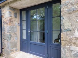 An entrance with double doors and a stone wall at Pen Y Cefn