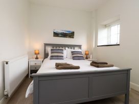 A bedroom with a bed and bedside table at Pen Y Cefn in Pen Y Cefn
